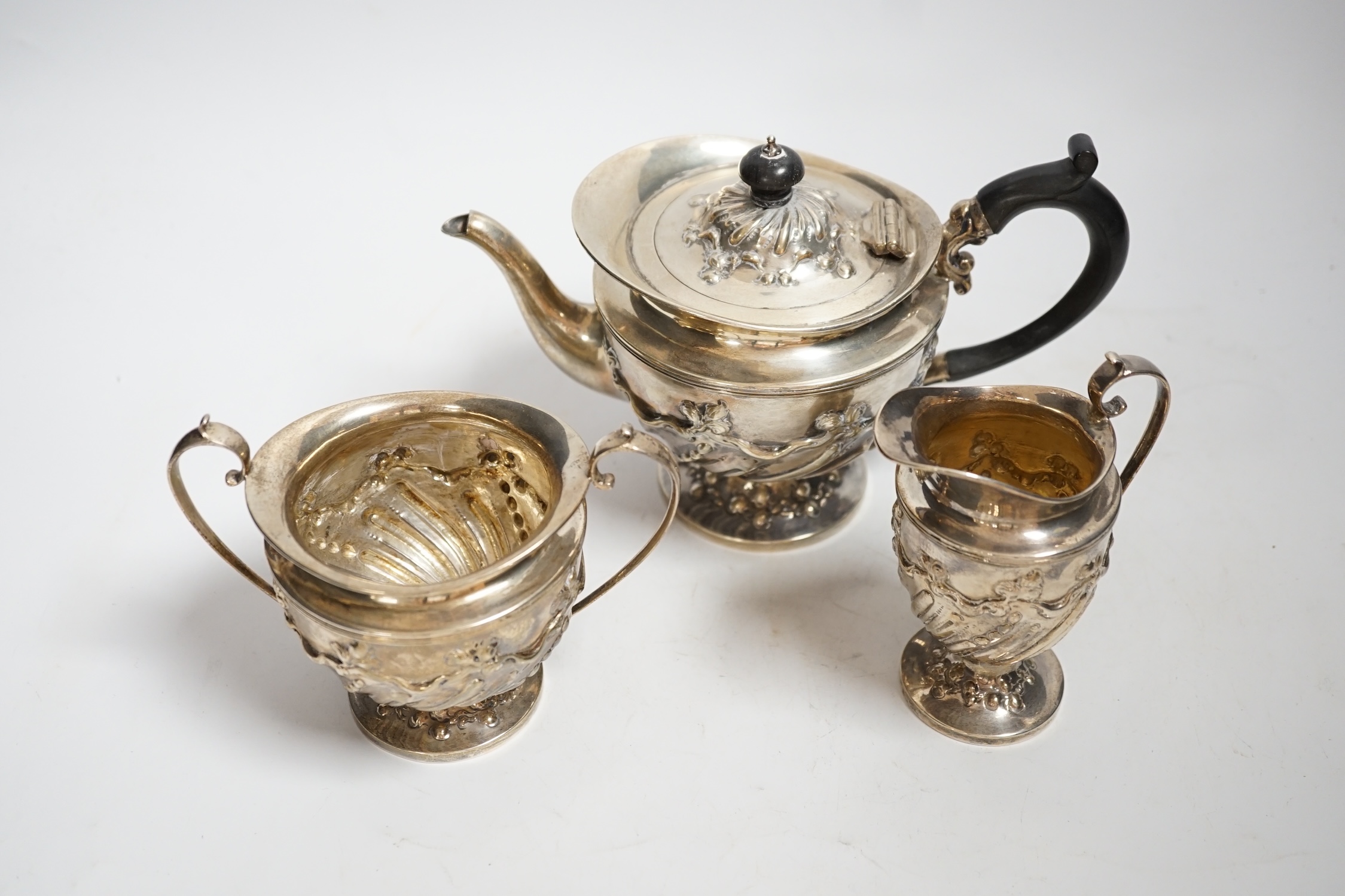 A late Victorian repousse silver three piece bachelor's tea set, double stamped maker's marks, London, 1890, gross weight 21.8oz.